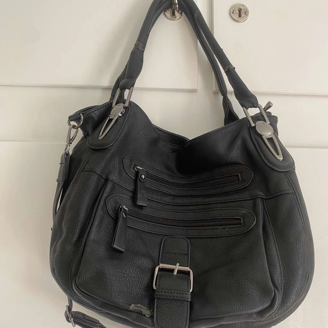 Svart axelväska med dragkedjor och spänne