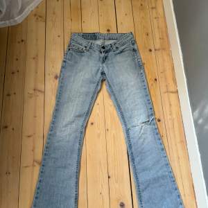 Jättesnygga lågmidjade jeans med ett hål på knät.💓 köpta här på Plick men säljer vidare dom. Midjemått rakt över: 35cm Innerbenslängd: 77cm. Passar någon runt 160-165 skulle jag tro.🫶🏼