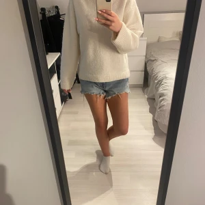 Blå jeansshorts från Zara - Säljer ett par snygga blå jeansshorts från Zara i storlek EU 36. De är perfekta för sommaren med en fräsch och avslappnad stil. Shortsen har en rå kant och en klassisk femficksdesign. Perfekta för en dag på stranden eller en somrig utflykt! 