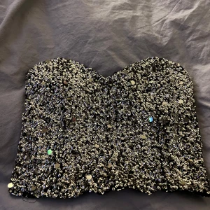 Glittrig topp - Korsettliknande topp från Gina tricot i storlek L