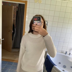 Vit ribbad tröja - Säljer en superfin vit ribbad tröja som är perfekt för kyligare dagar. Den har en hög krage och långa ärmar, vilket gör den både stilren och mysig. Passar perfekt till både jeans och kjol. Perfekt för höst och vinter! den är något genomskinlig.
