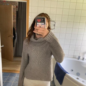 Stickad tröja  - Stickad grå tröja med hög hals, väldigt fin men något nopprig men det är inget man tänker på