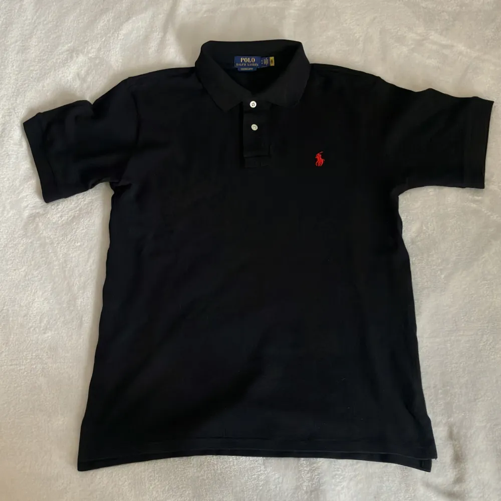 Svart piké från Polo Ralph Lauren i nyskick. Bara använd fåtal gånger & därför i 10/10 skick🤩 Köpt från CareOfCarl online & köpte fel storlek så därför säljes den. Storlek S & modell Custom slim Fit. Ord.pris 1399kr. Säljes för 599kr. Kan snacka pris. T-shirts.