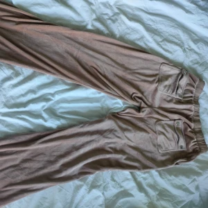 Beige mjukisbyxor med broderad logga - Säljer ett par superbekväma beige mjukisbyxor från juicy couture nästan helt nya bara använda fåtal gånger hemma. lite stora i storleken så de passar mig som har ungefär S.köpt för 1200kr
