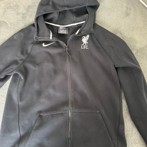 Fotbollströja  - En jätte fin Liverpool zip hoodie som är använd 1 gång och jag vill inte ha den längre ,  Storlek 158/170   Pris Kan diskuteras så skriv!!