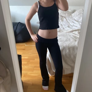 Svart ribbad linnetopp från BikBok - Säljer en svart ribbad linnetopp från BikBok i storlek XS. Toppen är ärmlös med smala axelband och har en croppad passform. Perfekt för sommardagar eller som ett basplagg i garderoben.