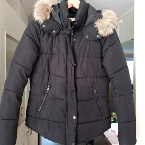 Svart jacka med luva stl 38 - Fin och välvårdad svart jacka med luva o pälskant stl 38.I nyskick.