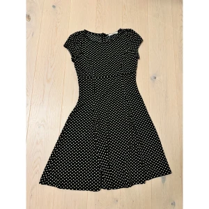 Svart kortklänning med vita prickar - Svart sommarklänning med vita prickar. Helt ny och oanvänd