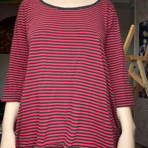 Röd och svart randig topp - Säljer en röd och svart randig topp med trekvartsärm. Den har en rund halsringning och är i en lös passform, perfekt för en avslappnad stil. Toppen är gjord i ett mjukt och bekvämt material.