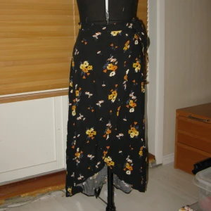 Blommig omlottskjol - Fin somrig omlottskjol!🌼 Har metallknäppen på insidan för att fästa och band på sidan. 