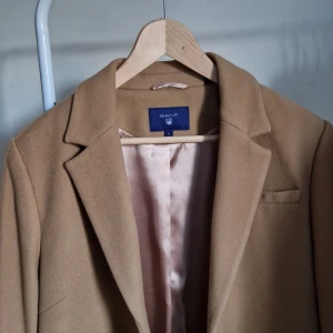 Kappa Gant Dam Stl L - Mycket sparsamt använd ullkappa. Kamelfärgad och klassiskt snitt. Knälång (jag är 163 cm)