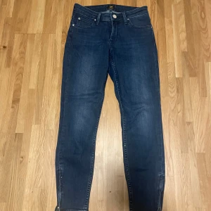 Blå jeans från Lee - Snygga blå jeans från Lee med klassisk femficksdesign och knappgylf. Perfekta för en avslappnad stil. Märkeslogga på baksidan av midjan. Aldrig använda💕💕