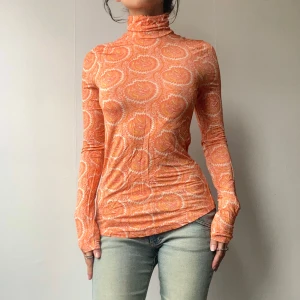 Orange topp - •Orange Paisly printed longsleeve turtleneck in soft jersey material  • SIZE - XS/EU 34/US 2 (Fits XS-S) • BRAND - & Other Stories • MATERIAL - 94% Viscose, 6% Elastane