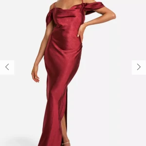 Vinröd långklänning i satin - Säljer denna oanvända vinröda långklänning i satin med offshoulder-design och slits. Perfekt för festliga tillfällen. Säljer en likadan i grön. Köpt på boohoo.