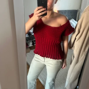 Röd stickad topp - Snygg röd offshoulder topp med ribbad design. Perfekt för en trendig look med korta ärmar och skön passform. Passar utmärkt till både jeans och kjol. 