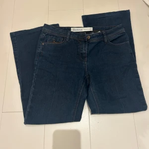 Mörkblå bootcut jeans från Next - Säljer ett par mörkblå bootcut jeans från Next. De har en klassisk femficksdesign och är tillverkade i ett slitstarkt denimtyg. Väldigt sköna. Passar någon som är ca 160