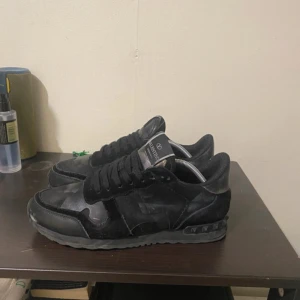 Valentino rockrunner - Snygga svarta sneakers från Valentino med diskret mönster och snörning. Perfekta för en stilren look. Storlek 40/41 skorna tvättas innan köp och kommer med extra glans till dig