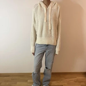 Vit stickad hoodie - Säljer en mysig vit stickad hoodie med långa ärmar och en stor huva. Perfekt för kyliga dagar när du vill vara både bekväm och stilren. Den har en ribbad kant vid ärmslut och nederkant. Säljer en likadan i svart!💓