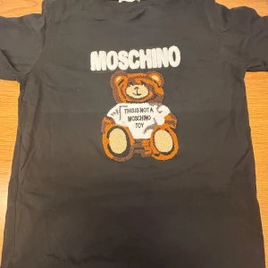 Moschino t shirt! - Snygg svart t-shirt från Moschino med ett stort nalletryck och texten 'This is not a Moschino toy'. Storlek large kontakta vid minsta intresse 