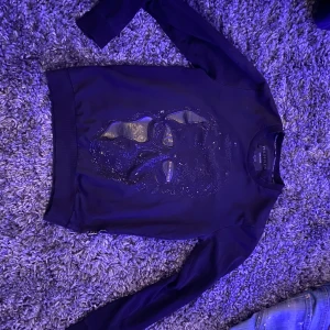 Svart tröja från Philipp Plein - Snygg svart tröja från Philipp Plein med ett glittrigt ansiktsmotiv på framsidan. Tröjan har långa ärmar och en ribbad krage. Perfekt för en stilren look. (Äkta) skriv om du har några frågor 