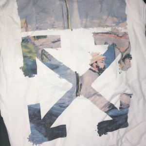 Vit hoodie från Off-White - Säljer en vit hoodie från Off-White med ett unikt grafiskt tryck på ryggen och ärmarna. Hoodien har en klassisk känguruficka och ribbade muddar. Perfekt för en stilren och modern look.