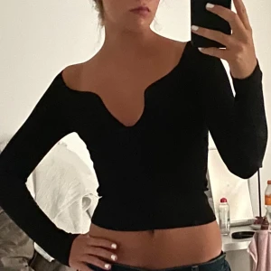 ASOS DESIGN - Snygg svart långärmad topp från ASOS DESIGN med en djup v-ringning. Perfekt för en stilren look. Tillverkad i ett mjukt och bekvämt material.