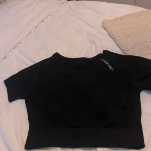 Svart kortärmad tröja från ICANIWILL - Säljer en svart kortärmad tröja från ICANIWILL. Perfekt för träning med sin bekväma passform och stilrena design. Tröjan har en diskret logga på bröstet.