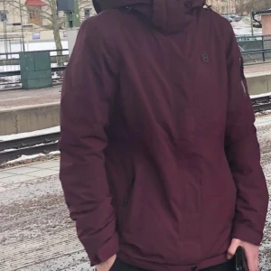 Vinröd jacka med huva - Snygg vinröd jacka med huva och dragkedja framtill. Perfekt för kyligare dagar med sin stilrena design och praktiska fickor.