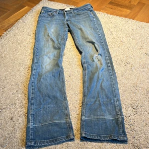 Lågmidjade bootcut jeans - Så fina Lågmidjade bootcut vintage jeans från Filippa K i storlek 28, skulle säga är ungefär som S/M❤️ Har varit uppsydda därför har det slitningar vid slutet av benet men syns inte så mycket när man har de på, det har ett hål på knät också💕priset är såklart diskuterbart skicka gärna prisförslag!