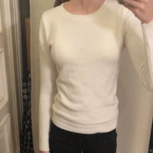 Vit stickad tröja - Säljer en stilren vit stickad tröja med långa ärmar. Perfekt för kyligare dagar och lätt att matcha med olika outfits. Tröjan har en klassisk design med ribbstickade muddar vid ärmslut och nederkant. 💕