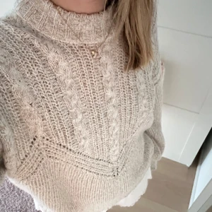 Stickad tröja  - Beige stickad tröja med detaljer! Endast använd fåtal ggr, inga noppor! Köpt på Nelly