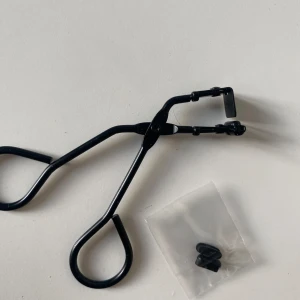 Svart ögonfransböjare - Säljer en svart mini ögonfransböjare i metall. Denna fransböjare kommer in där det inte gick att böja från den vanliga fransböjaren ex vid ögonvrån eller på sidan. Den har en klassisk design med bekväma handtag och kommer med extra gummidynor för att ge dina fransar en perfekt böj. Perfekt för att få till den där dramatiska looken! 🖤