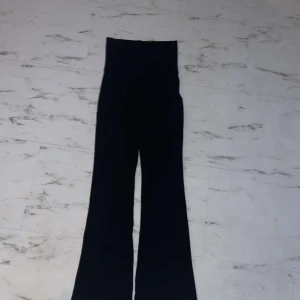 Svarta byxor från Gina Tricot - Säljer ett par svarta byxor från Gina Tricot. Dom går att ha både uppvikta eller nedvikta( joggapants) och har en bootcut-stil som ger en snygg siluett. Perfekta för både vardag och fest.