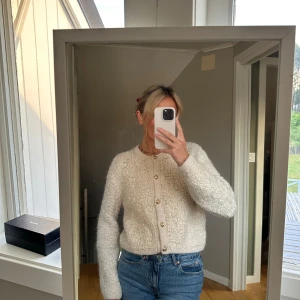 Beige stickad kofta - Säljer en supermysig beige stickad kofta med knappar. Perfekt för höst och vinter, den är både varm och stilren. Koftan har långa ärmar och en normal passform. Passar perfekt till jeans för en avslappnad look!