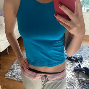 Blå ärmlös topp från ComProBase - Säljer en snygg blå ärmlös topp från ComProBase. Perfekt för sommardagar eller träning. Toppen passar en xs och har en tight passform som framhäver figuren. Materialet är mjukt och bekvämt, vilket gör den idealisk för både vardag och aktivitet.