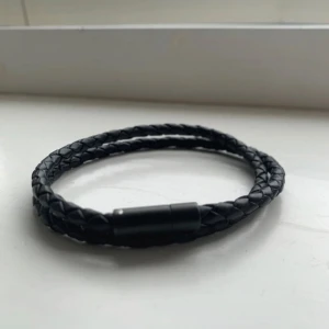 Svart flätat armband från Skultuna - Snyggt svart flätat armband med en stilren design. Armbandet har en diskret magnetlåsning som gör det enkelt att ta på och av. Perfekt accessoar för en minimalistisk look. Från Skultuna.