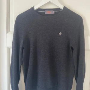 Mörkgrå ulltröja från Morris - Säljer en stilren mörkgrå tröja från Morris i 100% merinoull. Tröjan har en liten broderad logga på bröstet och långa ärmar. Perfekt för kyligare dagar. Kan gå ner i pris vid snabb afffär.