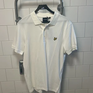 Vit pikétröja från Lyle & Scott - Säljer en stilren vit pikétröja från Lyle & Scott med klassisk krage och knappslå. Aldrig använt så helt ny. Försöker frakta samma dag 