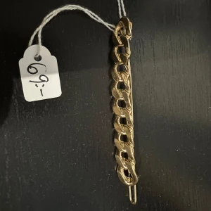 Guldfärgad hårklämma med kedjedesign - En stilren guldfärgad hårklämmamed en unik kedjedesign. Perfekt som en dekorativ detalj på kläder eller accessoarer. Den mäter cirka 11 cm i längd och har en elegant och modern look.