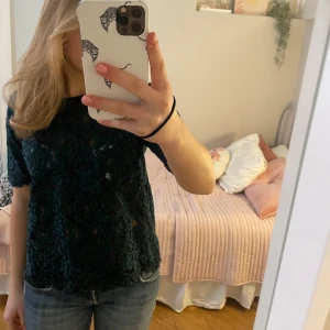 Mörkgrön spetsblus - Säljer en elegant mörkgrön spetsblus med korta ärmar och ett vackert mönster💗 Står ingen storlek men kan passa folk mellan Xs-L beroende på vilken pssform man söker🥰 Själv har jag S i vanliga fall