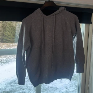 Grå ull hoodie - Säljer en helt ny grå ull hoodie, bekvämt och mjukt material ändå nackdel är att den är liten i storleken som ni kanske ser. Aldrig använd