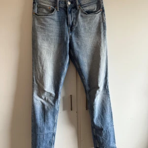 Blå slim jeans från H&M - Snygga blå slim jeans från H&M med klassisk femficksdesign och knappgylf. Perfekta för en stilren look. Tillverkade i ett bekvämt denimtyg som ger en skön passform. 