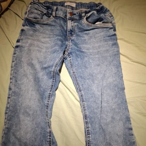 Blå jeansbyxor från Lindex - Säljer ett par snygga blå jeansbyxor från Lindex. De har en klassisk femficksdesign med knapp och dragkedja framtill. Perfekta för en avslappnad stil.
