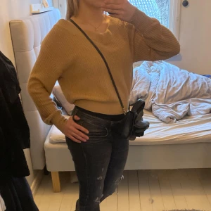 Beige stickad tröja från Gina Tricot - Säljer en snygg beige stickad tröja från Gina Tricot. Tröjan har en v-ringad design och långa ärmar, perfekt för en avslappnad stil. Den är i storlek S och passar bra till jeans eller kjol. Perfekt för höst och vinter!