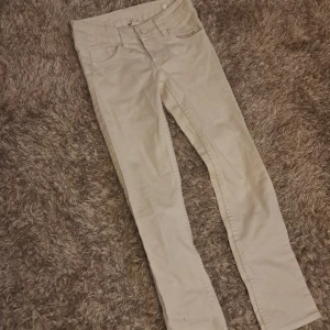 Vita byxor från H&M Young - Säljer ett par stilrena viya byxor från H&M Young. Byxorna har en klassisk design med fickor både fram och bak. Perfekta för en avslappnad look.🤍