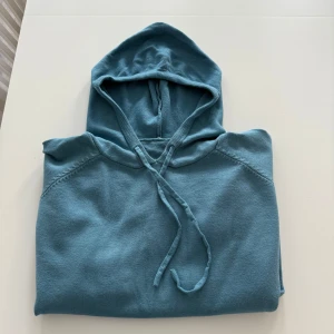 Blå hoodie i merinoull  - Säljer en riktigt stilren blå hoodie i merinoull! Skick 10/10, aldrig använd. Storlek M, passar XS. Riktigt skönt material. Pris kan diskuteras! Skriv vid funderingar! :)
