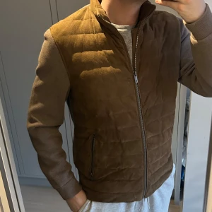 Cardigan från Massimo Dutti mocka - Säljer en snygg brun / beige cardigan i mocka från Massimo Dutti. Perfekt för vår! XL på taggen men passar L 