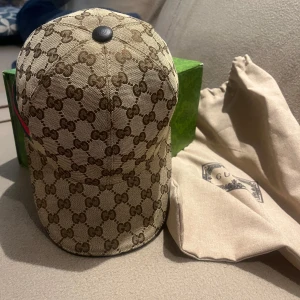 Gucci Keps Beige  - Snygg beige Gucci keps. Knappt använd, i riktigt bra skick som ny. Säljer eftersom jag fick en ny som present. Lådan dustbag följs med. Inte äkta men är omärkligt. 