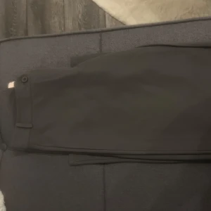 Grå kostymbyxor från Nelly - Snygga grå lågmidjade kostymbyxor från Nelly i storlek S. Aldrig använda. Säljer då jag inte passade i färgen