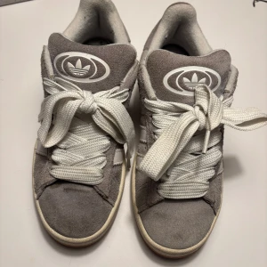 Gråa Adidas Campus 00s - Säljer nu mina gråa Adidas campus 00s som jag har använt mycket i våras pågrund av att de ej kommer till användning längre ❤️